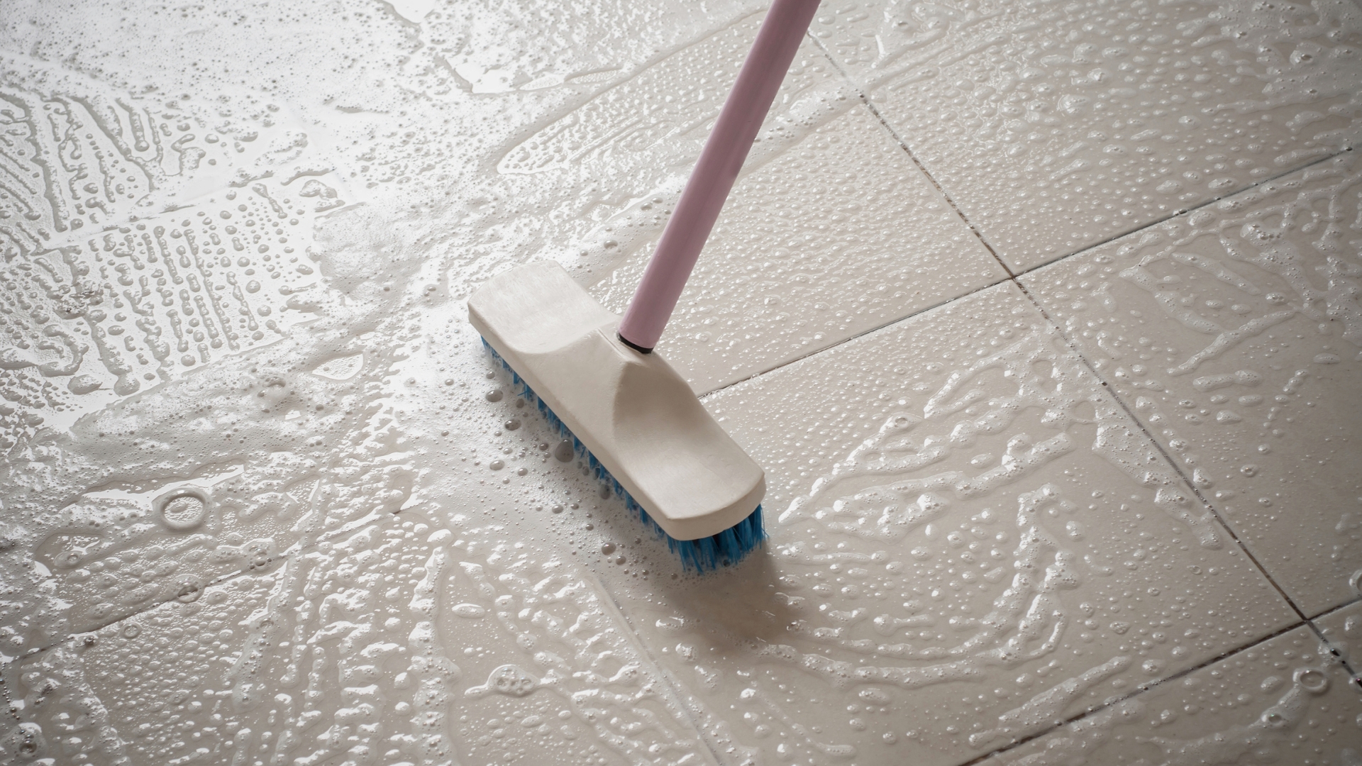 A mop is laying on a tiled floor